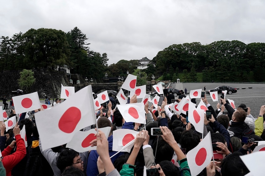 people waving Japanese flags.