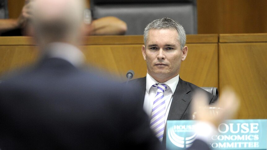 Labor backbencher Craig Thomson listens to RBA governor Glenn Stevens in Canberra on February 19, 2010.