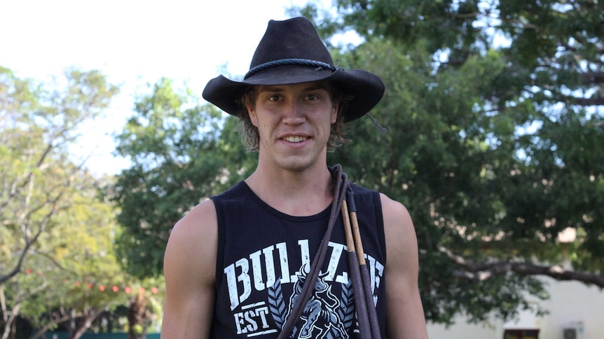 A man in a hat with whips around his neck.