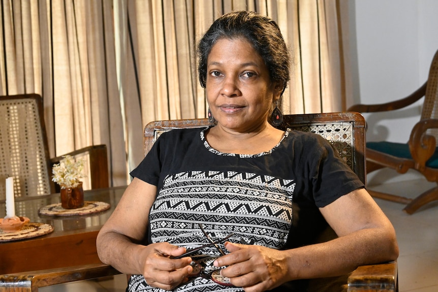 Professor Sumathy Sivamohan sits in a chair, facing the camera. 