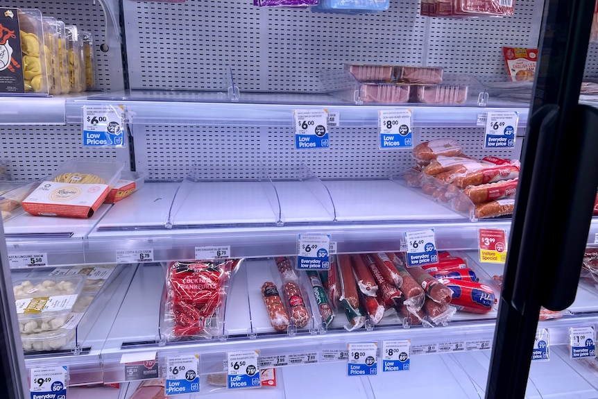 A near empty fridge of meat products