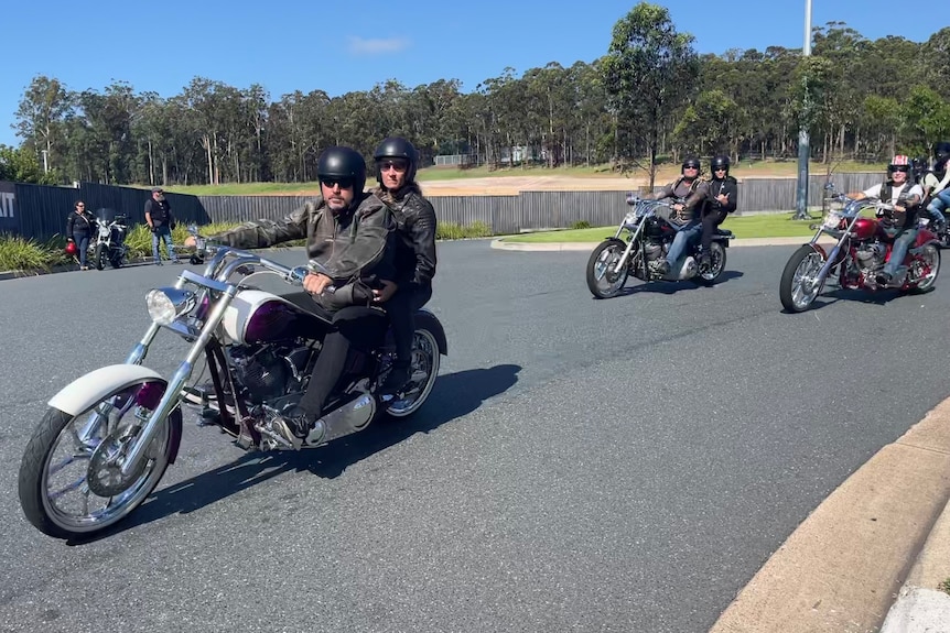Motorcyclists ride along a local road.