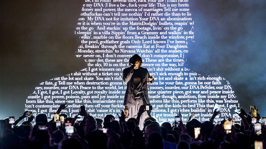 Kendrick Lamar performs live at Spotify Beach event at 2022 Cannes Lions Festival against a backdrop of his song lyrics