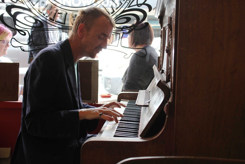 Bill Longo playing the piano in a Hobart cafe.