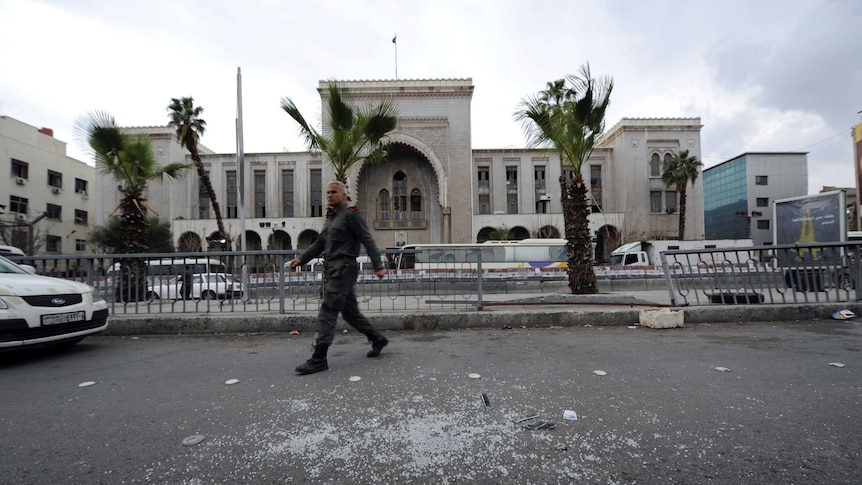 A security guard walks across the road.