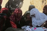 Afghan women cry over the bodies of civilians killed in a suicide attack in Baghlan province