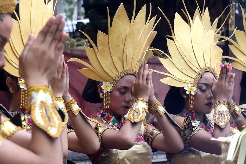Women dancers pray before their perform during culture parade.