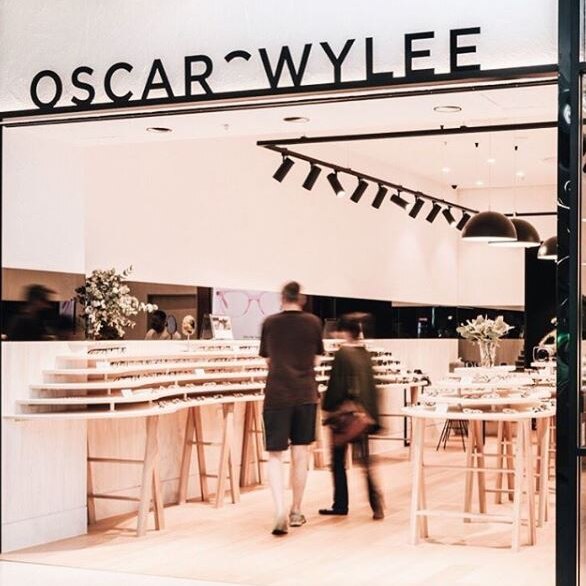 An Oscar Wylee shopfront featuring the brand's logo and two people looking at glasses.