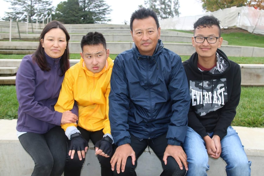 A mother and father sitting with their two teenage sons.