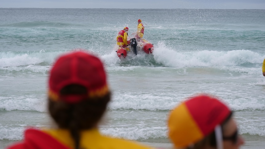 An inflatable rescue boat powers through the shallows, bound for the deep.