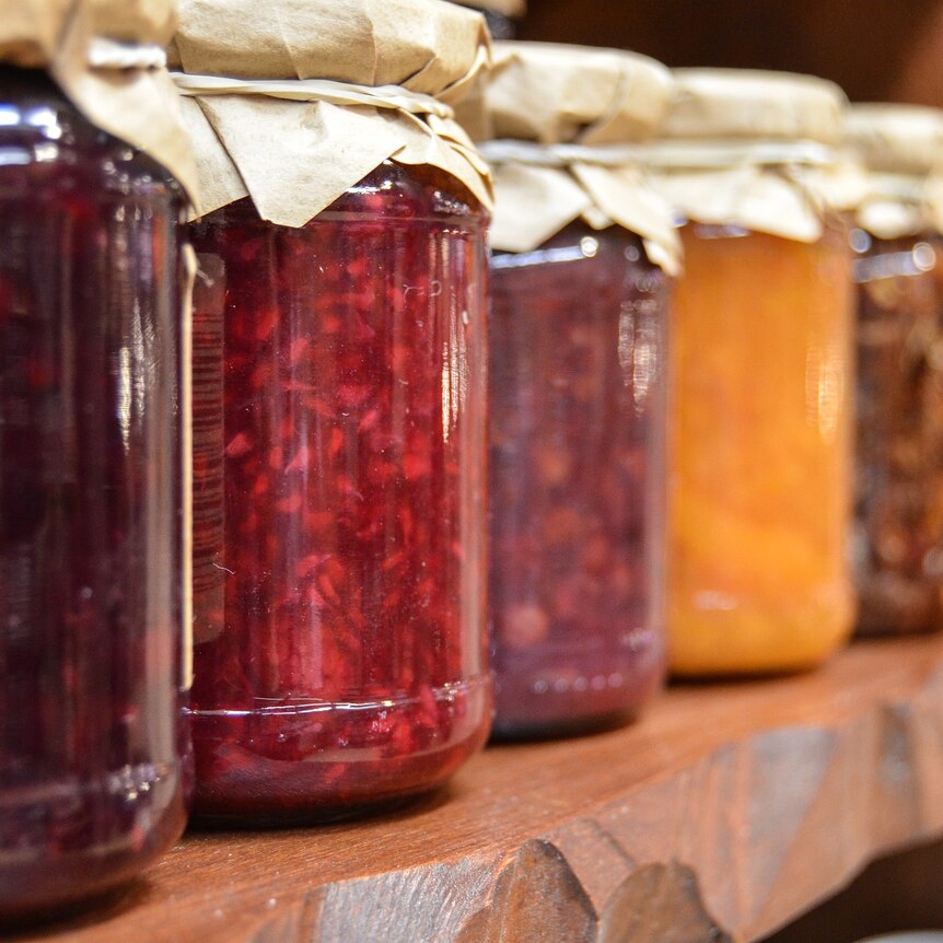 A row of bottles of different coloured jams