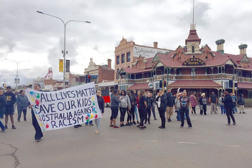 Protestors gather on Hannan Street in Kalgoorlie with banners.