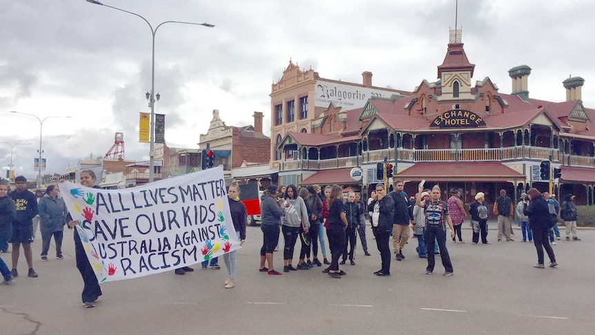 Protesters gather on Hannan Street in Kalgoorlie with banners.