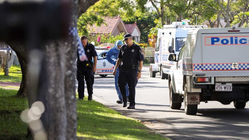 Police officers look at a footpath outside a suburban home where a man was shot.
