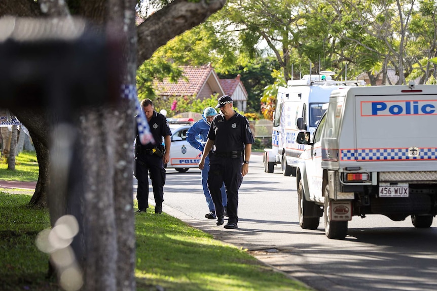 Police officers look at a footpath outside a suburban home where a man was shot.