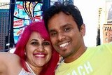 Meenakshi Moorthy, with bright pink hair, and her husband Vishnu Viswanath smile at the camera with their arms around each other