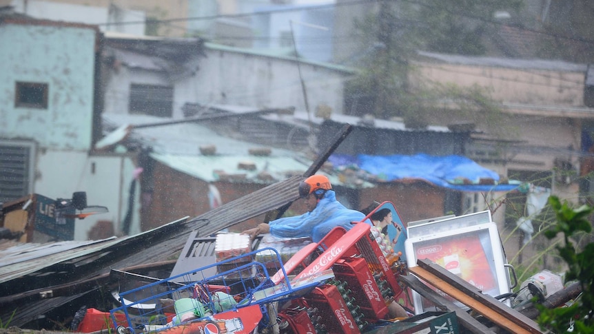 Man looks through damaged home in Vietnam