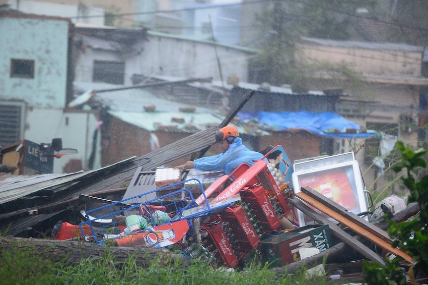 Man looks through damaged home in Vietnam