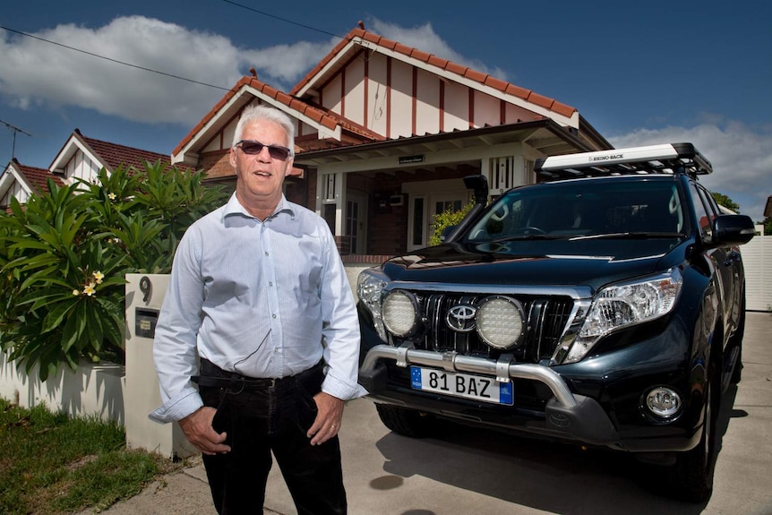 Max Bancroft at home in his front yard standing next to his Toyota Prado.