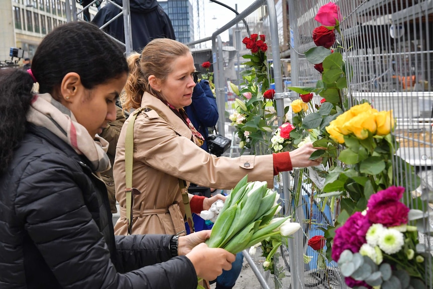 People lay flowers near where the truck attack happened.