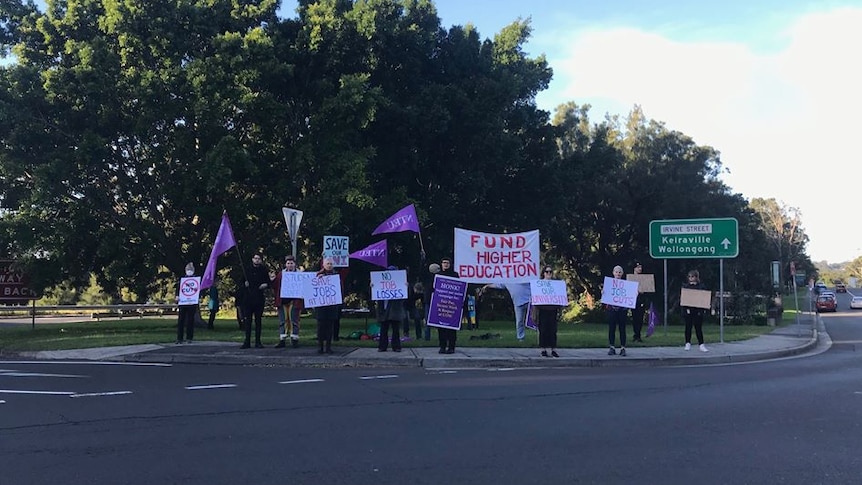 A dozen academics holding signs and banners protesting against cuts to the University of Wollongong.