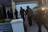 Police officers outside a house