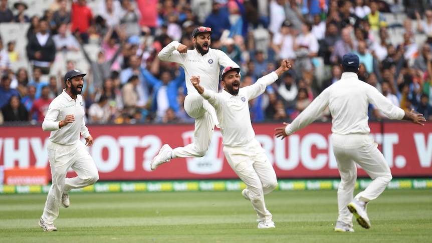 Indian players Cheteshwar Pujara, Virat Kohli and Ajinkya Rahane smile and cheer in the field as India wins a Test at the MCG.
