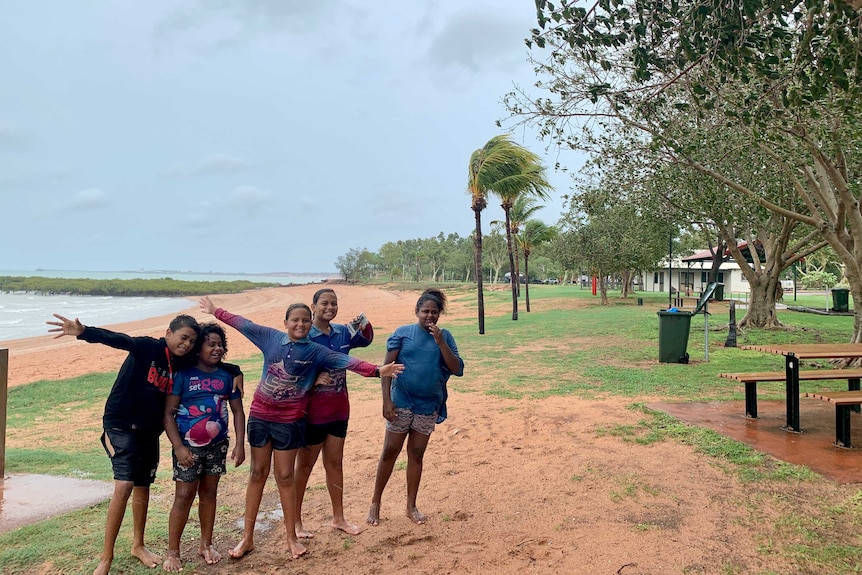 Kids smile on a beach playing in wet weather