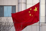 A Chinese flag flies in front of a courthouse in China.