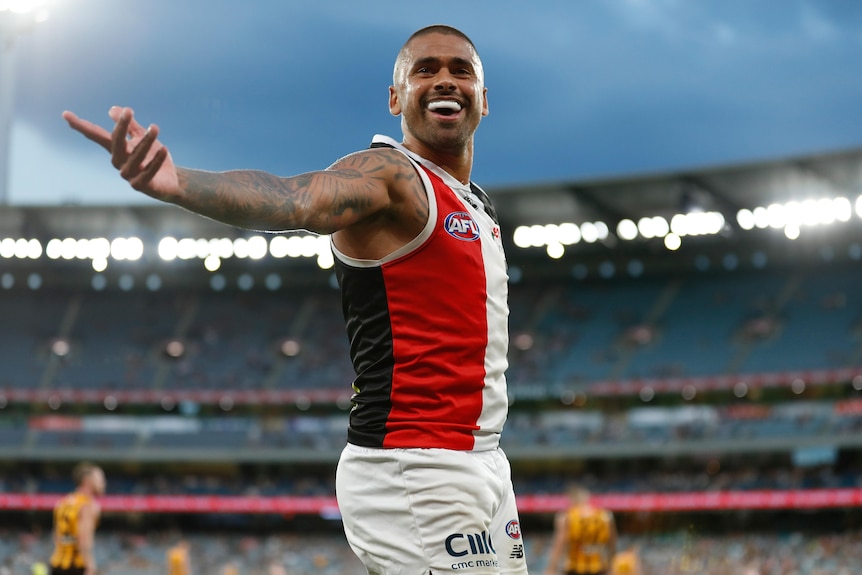 Bradley Hill holds his arm out and smiles as he looks into the crowd