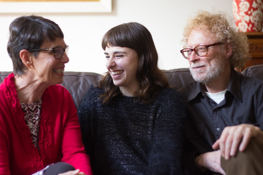 Three members of a support group for people with BDD chat on a couch