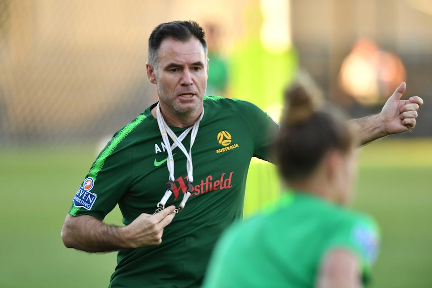 Football coach and a player training at an oval.