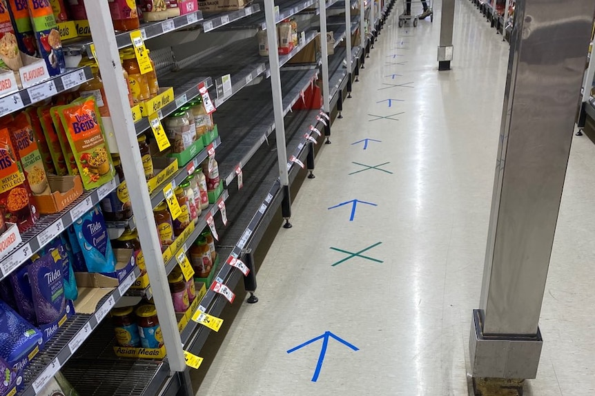 Blue arrows separate green crosses to indicate the spacing required for customers along the aisle of a supermarket.