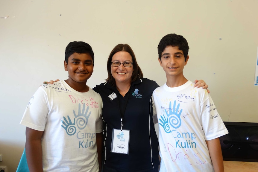 Two teenage boys and a woman standing together