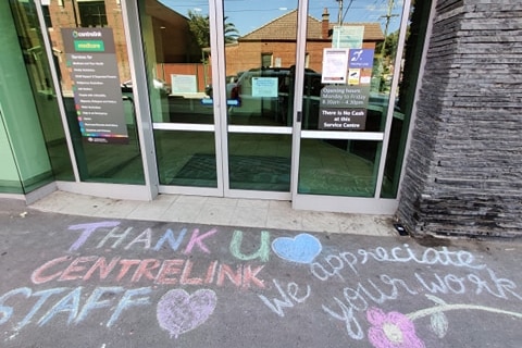 Chalked pavement outside the office reads: Thank u Centrelink Staff - we appreciate your work