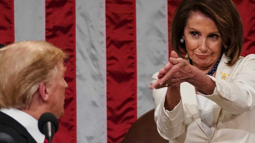 Man turning back to look at a woman wearing a white suit.