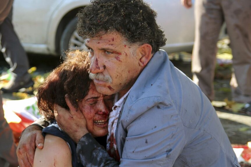 Injured man hugs an injured woman after an explosion during a peace march in Ankara, Turkey