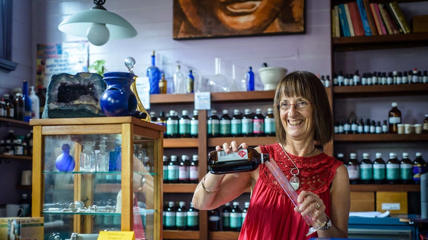 Nimbin apothecary Diana Roberts pours a bottle into a tube in her shop.