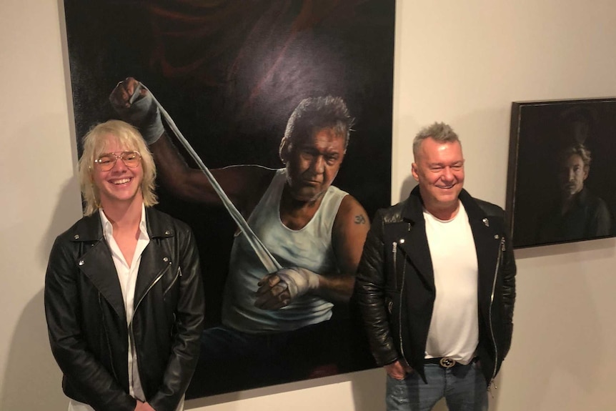 Artist Jamie Preisz and Jimmy Barnes stand with the winning portrait.