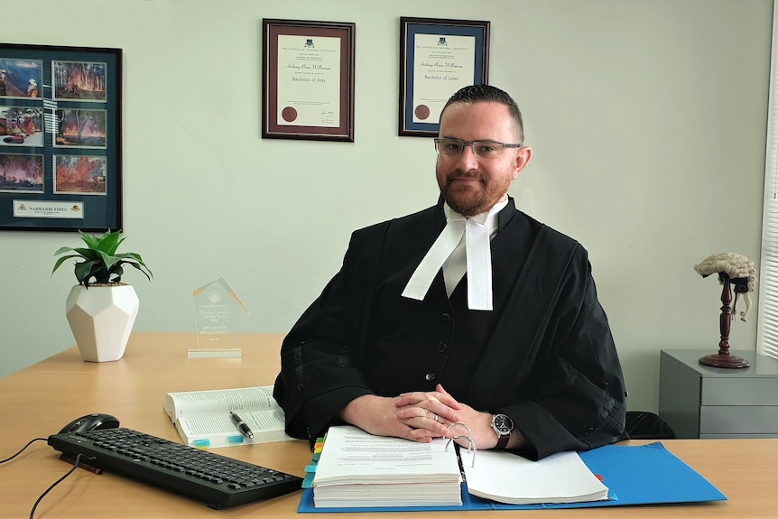 Anthony Williamson sitting at a desk wearing a black court robe. 