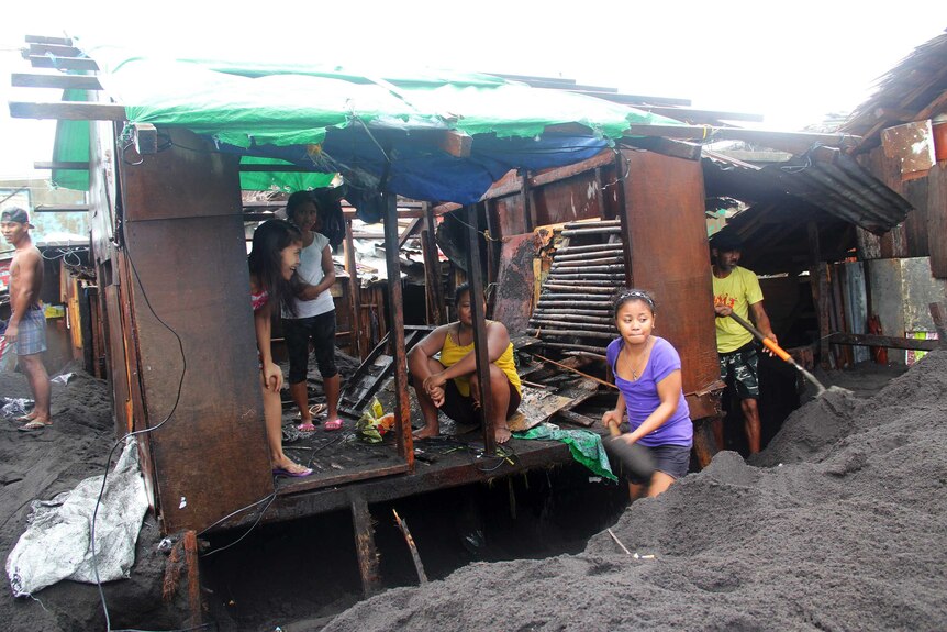People return to partially buried homes after typhoon Hagupit swept through Legazpi city, Philippines