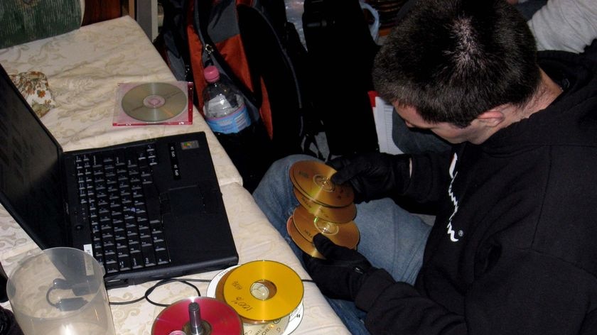 A Federal Police officer handles CDs during a raid.