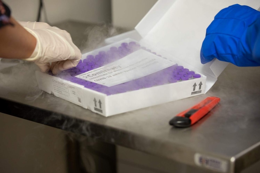 A close up of the vials of the COVID-19 vaccine with mist around them.