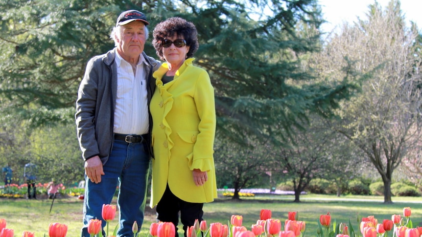 Tulip Top garden owners stand in front of flower bed.