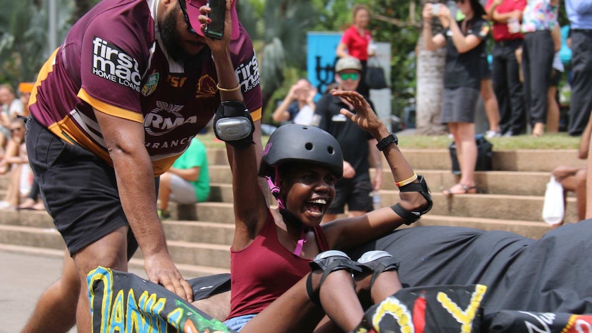 A young girl races on a couch in Darwin.