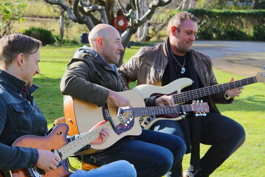 The Wolfe Brothers band perform a song outside.