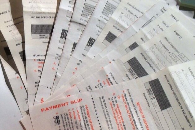 A stack of fines are fanned out on a table.