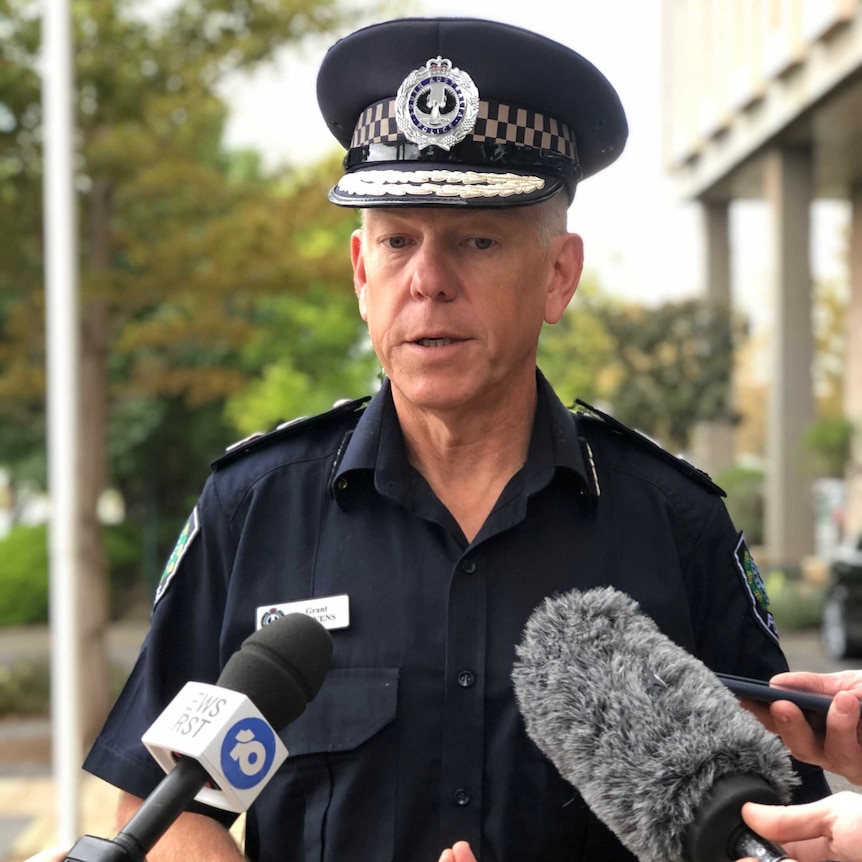 A police officer speaks to the media outside of a building