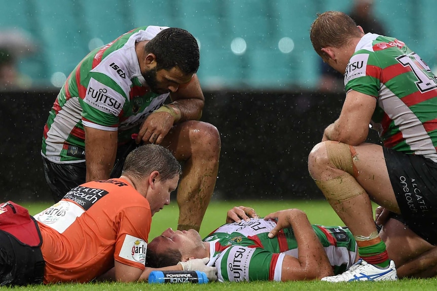 Sam Burgess is seen to by trainers after sustaining an injury against the Dragons