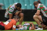 Sam Burgess is seen to by trainers after sustaining an injury against the Dragons